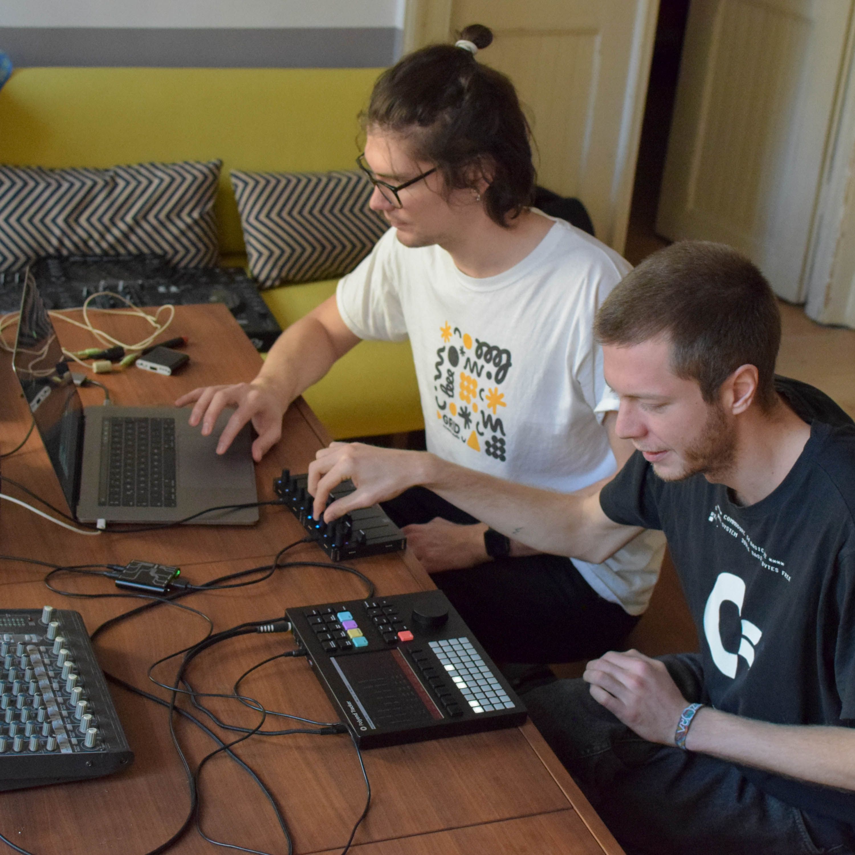 Men in front of a laptop with studio gears and Grid controllers