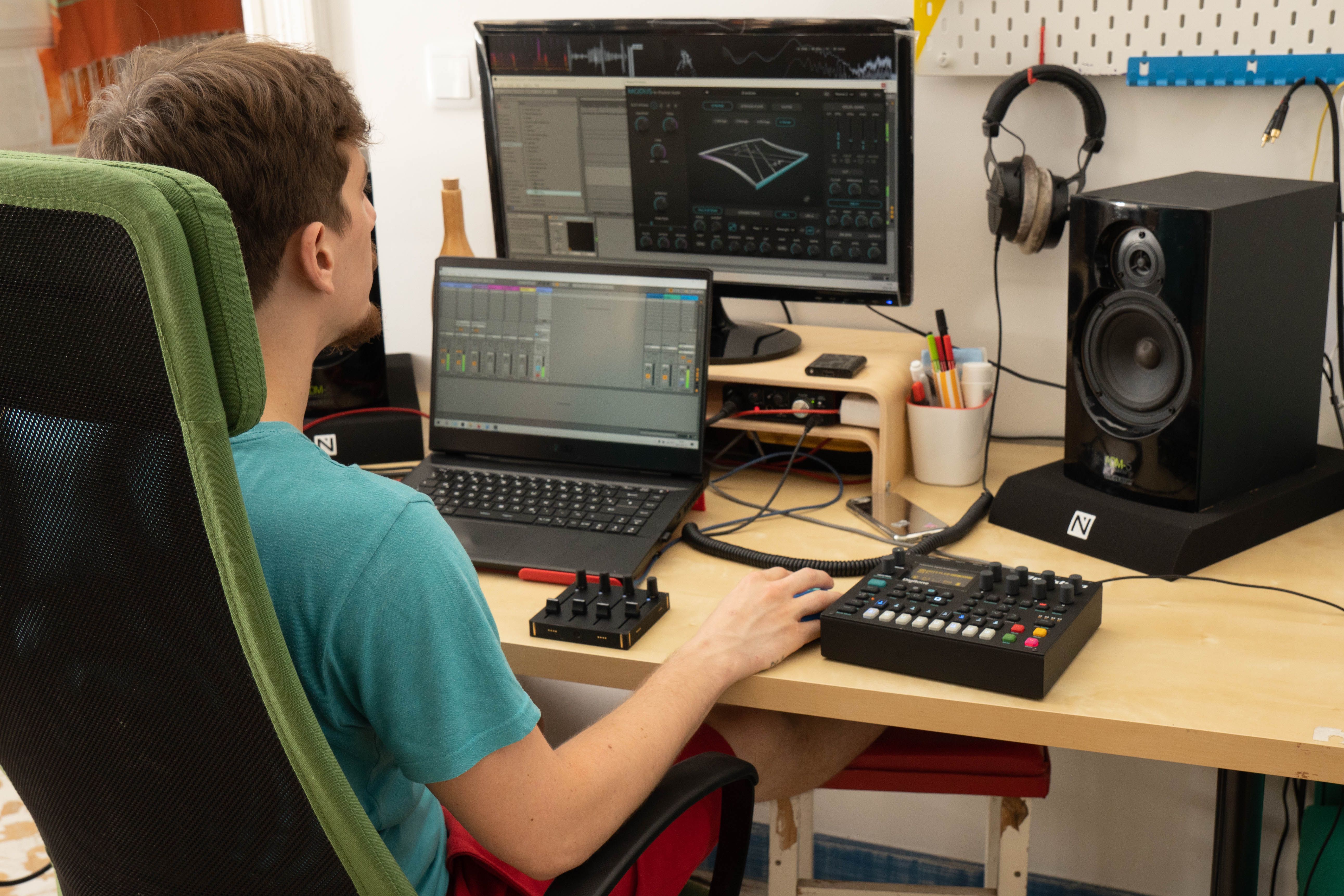 Man in front of a laptop with studio gears and a Grid controller