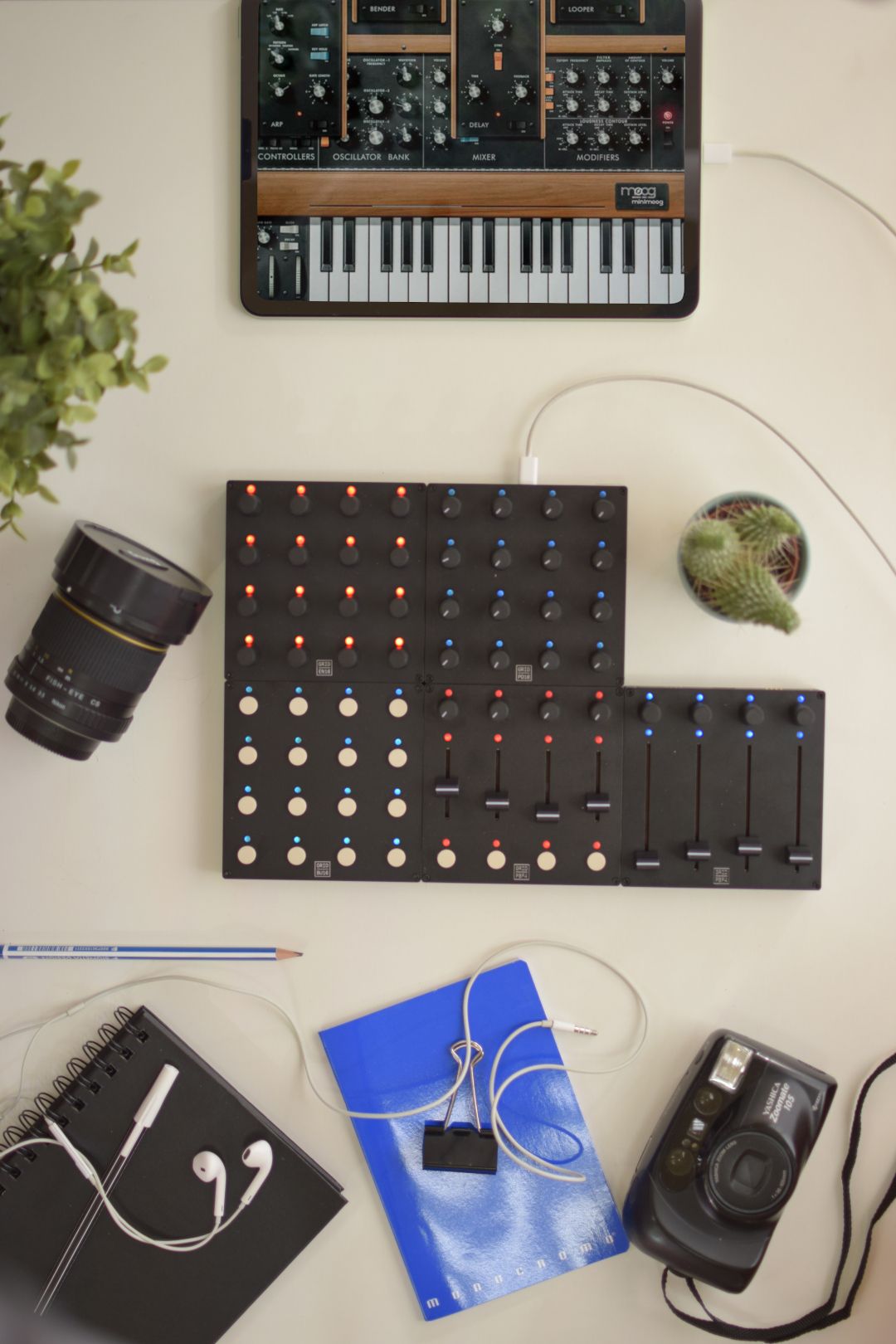 Grid controllers, photo and music gear on a white surface
